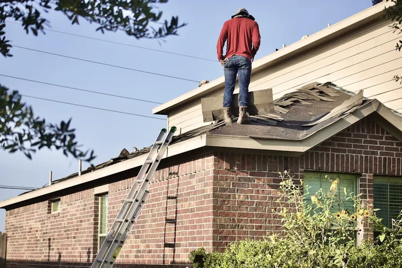 Professional roofer working on a residential roof in West Springfield Town